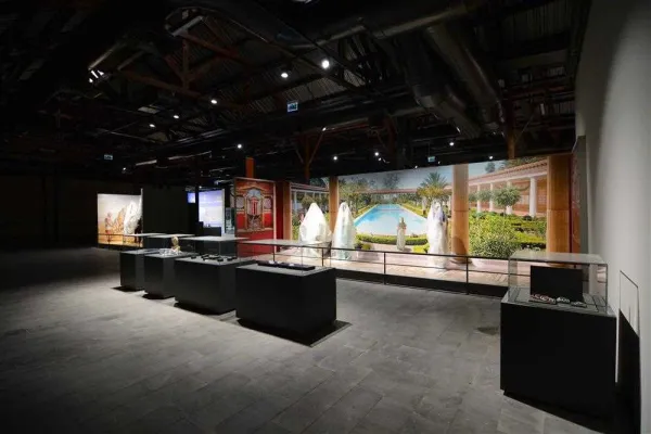 Adana Müzesi'nde ferah bir sergi alanı, palmiye ağaçları ve havuz ile sıcak bir atmosfer.