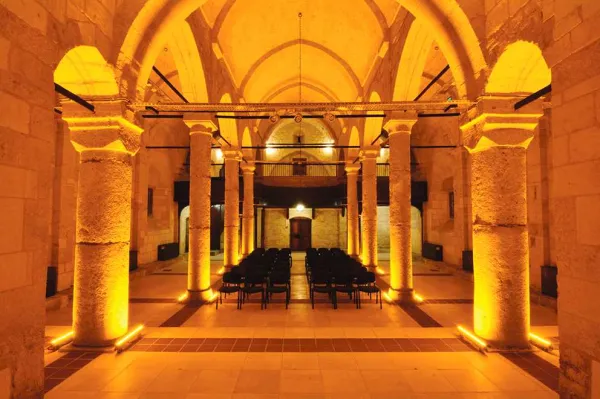 Tarihi mekanın sıcak atmosferi, taş yapılar ve altın sarısı aydınlatma ile dolu.