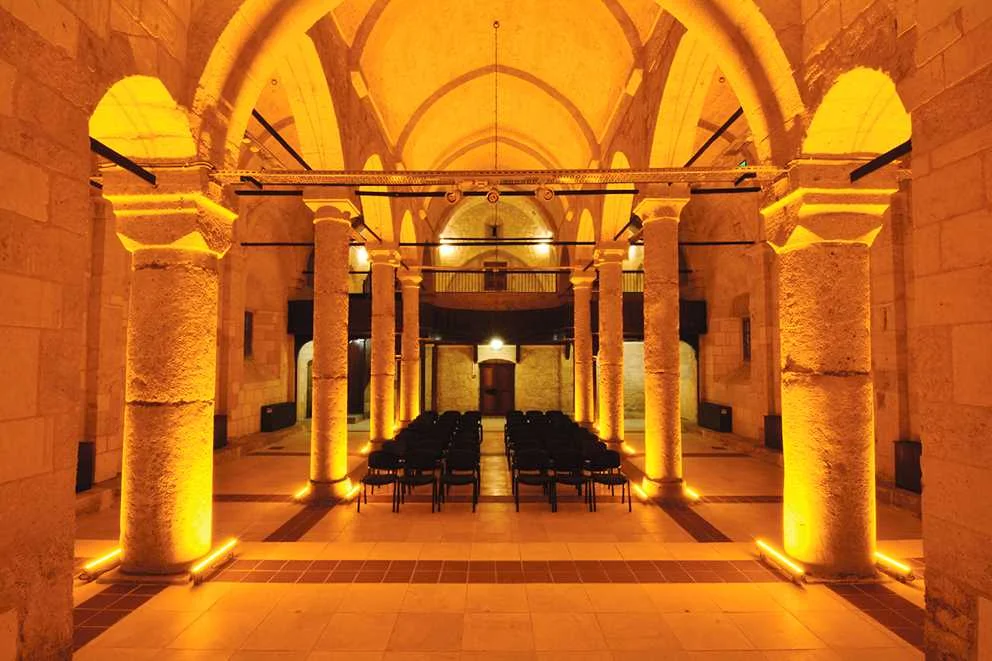 Kuruköprü Anıt Müzesi ve Geleneksel Adana Evi Tarihi mekanın sıcak atmosferi, taş yapılar ve altın sarısı aydınlatma ile dolu.