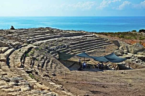 Magarsus Antik Kenti Tiyatrosu Magarsus Antik Kenti'nde deniz manzaralı tiyatro, yaz mevsiminde tarihi keşif atmosferi.