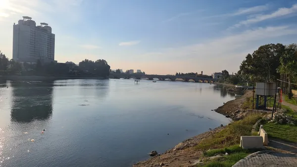 Taş köprü, nehir, ağaçlar ve huzurlu bir doğal ortam.