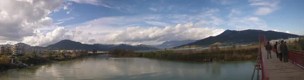 Taş köprüde yürüyen insanlar ve doğal manzara görünümü