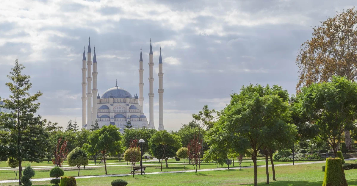 Yeşil ağaçlar arasında yükselen Sabancı Merkez Cami'nin zarif kubbesi ve minareleri