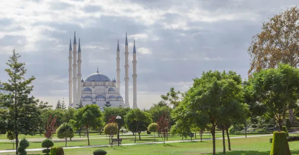 Yemyeşil parkta yüksek minaresiyle Sabancı Merkez Camii ve çevresindeki ağaçlar