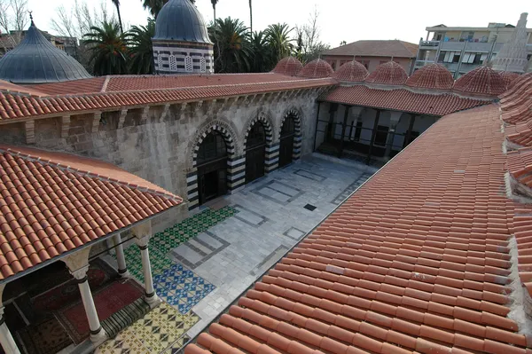 Adana Ulu Camii avlusu, halılar ve geleneksel kubbelerle çevrili.