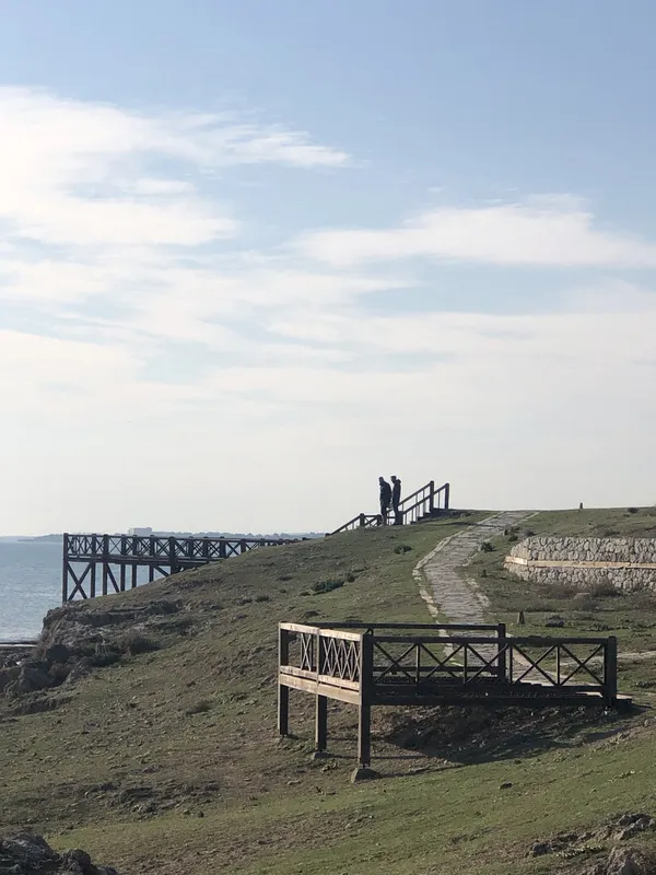 Ayas Antik Kenti'nde deniz ve yeşil tepe manzarası.
