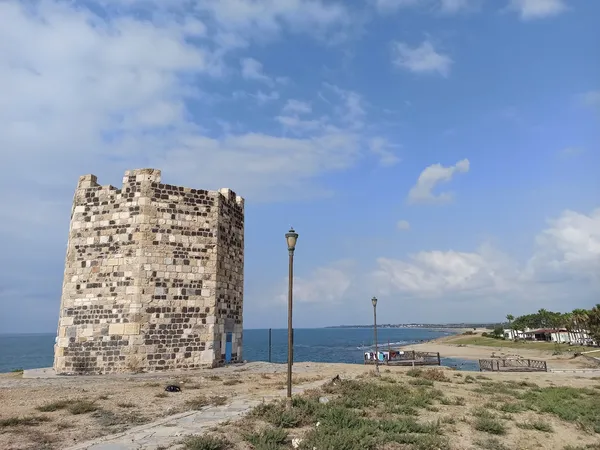 Ayas Antik Kenti'nde deniz kenarındaki tarihi kule ve manzara.