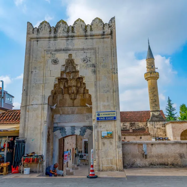 Tarihi Yağ Camii'nin süslü giriş kapısı ve etrafındaki dükkanlar.