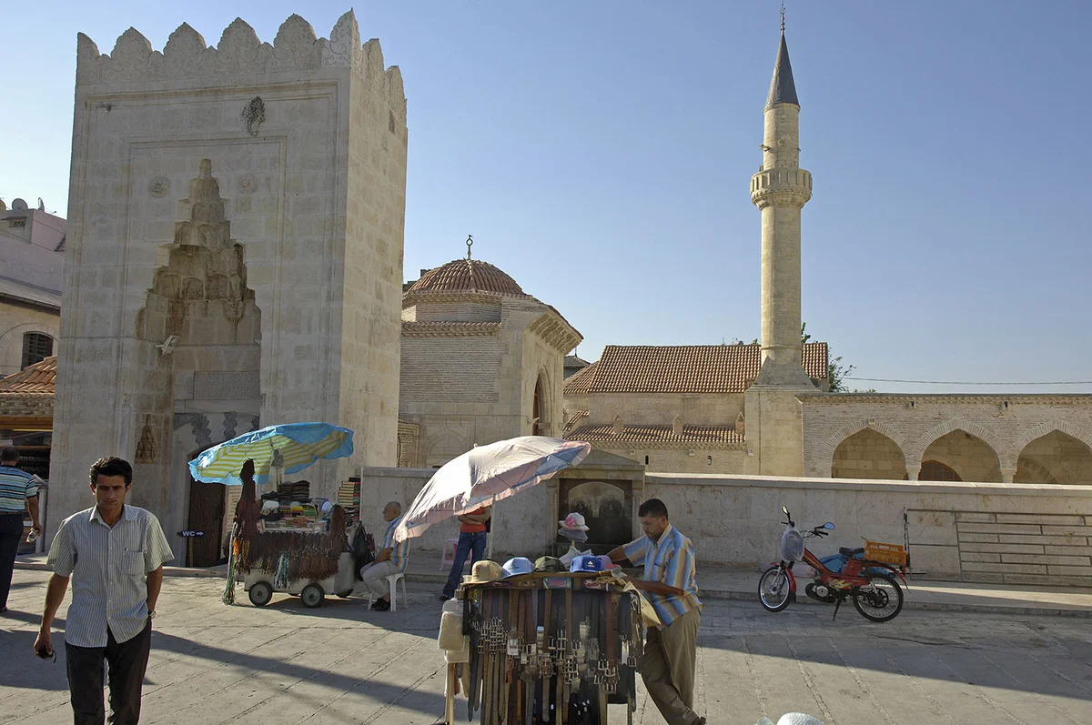 Yağ Camii ve Tarihi Alan Görüntüsü Yağ Camii'nin tarihi yapıları, satıcılar ve güneşli atmosfer.