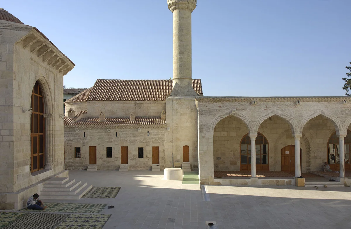 Yağ Camii - Tarihi Yapı ve Avlu Yağ Camii'nin avlusunda tarihi taş işçiliği ve minare görüntüsü.