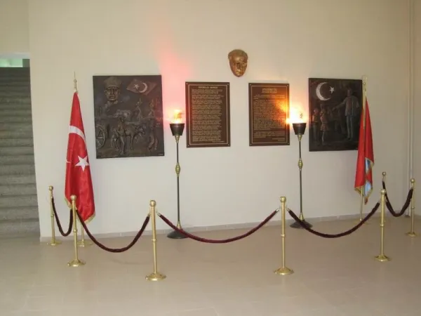 Büyük Türk bayrağı ve heykel ile aydınlatılan düzenli bir anıt alanı