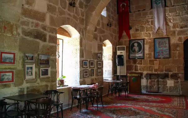 Geniş tarihi bir salon, taş duvarlar ve ahşap mobilyalarla sıcak bir atmosfer sunuyor.