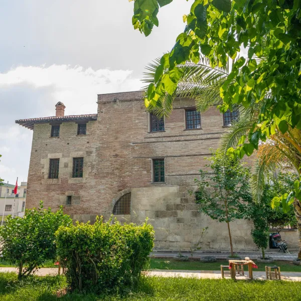 Tarihi Ramazanoğlu Konağı'nın dış cephesi, yeşil bitkilerle çevrili.