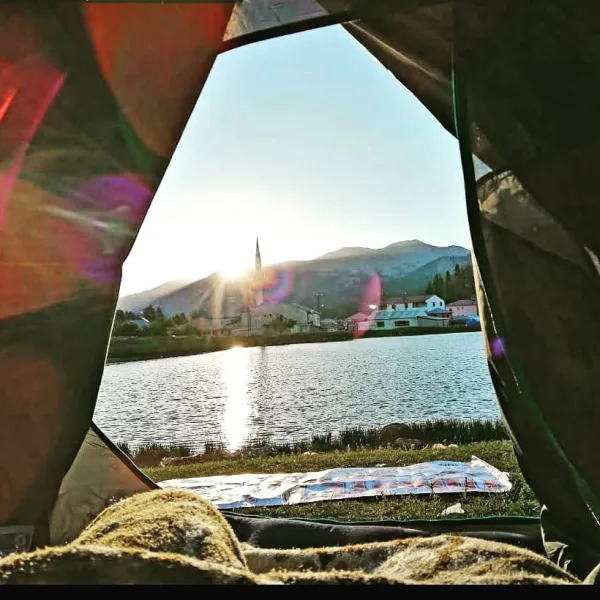 Çadırdan görünen güneşin doğuşu ve gölet manzarası.