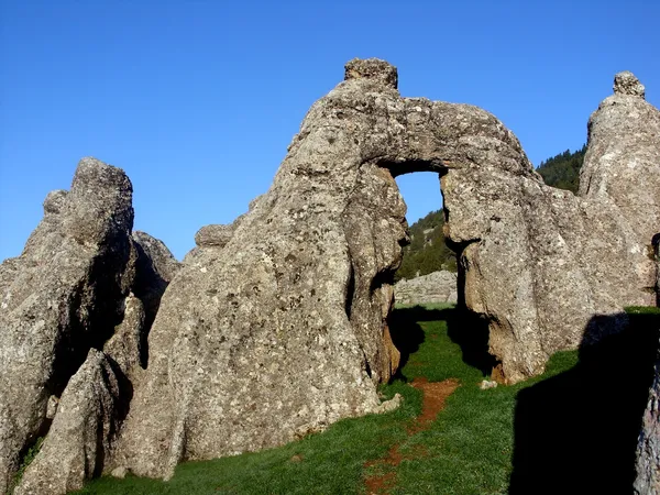 Kozan Göller Yaylası'nda büyük kayalar ve yeşil alan manzarası.