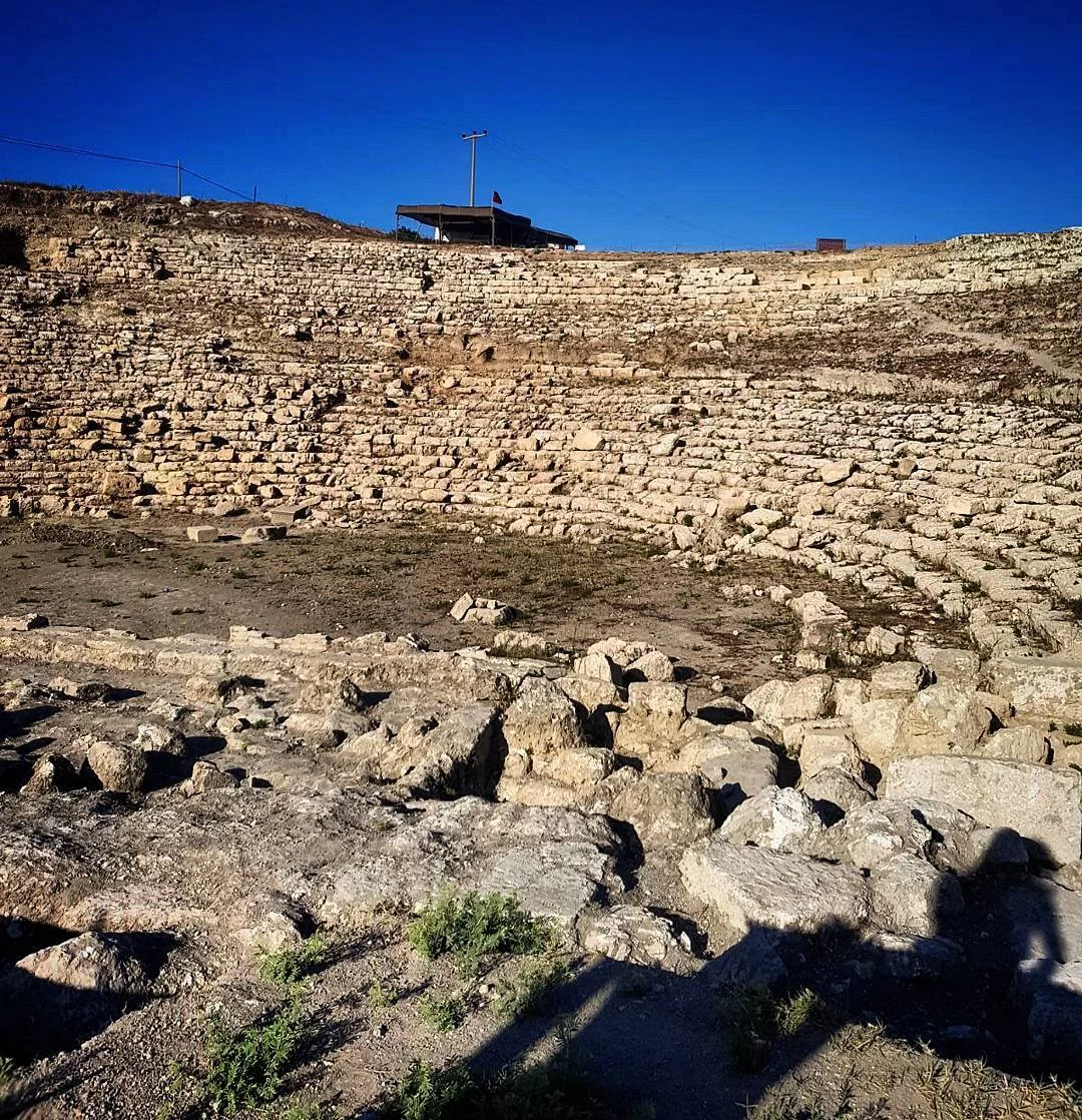 Magarsus Antik Kenti'nde Tarihi Amfitiyatro Kalıntıları Antik amfitiyatronun kalıntıları, mavi gökyüzü ve bayrak ile birlikte.