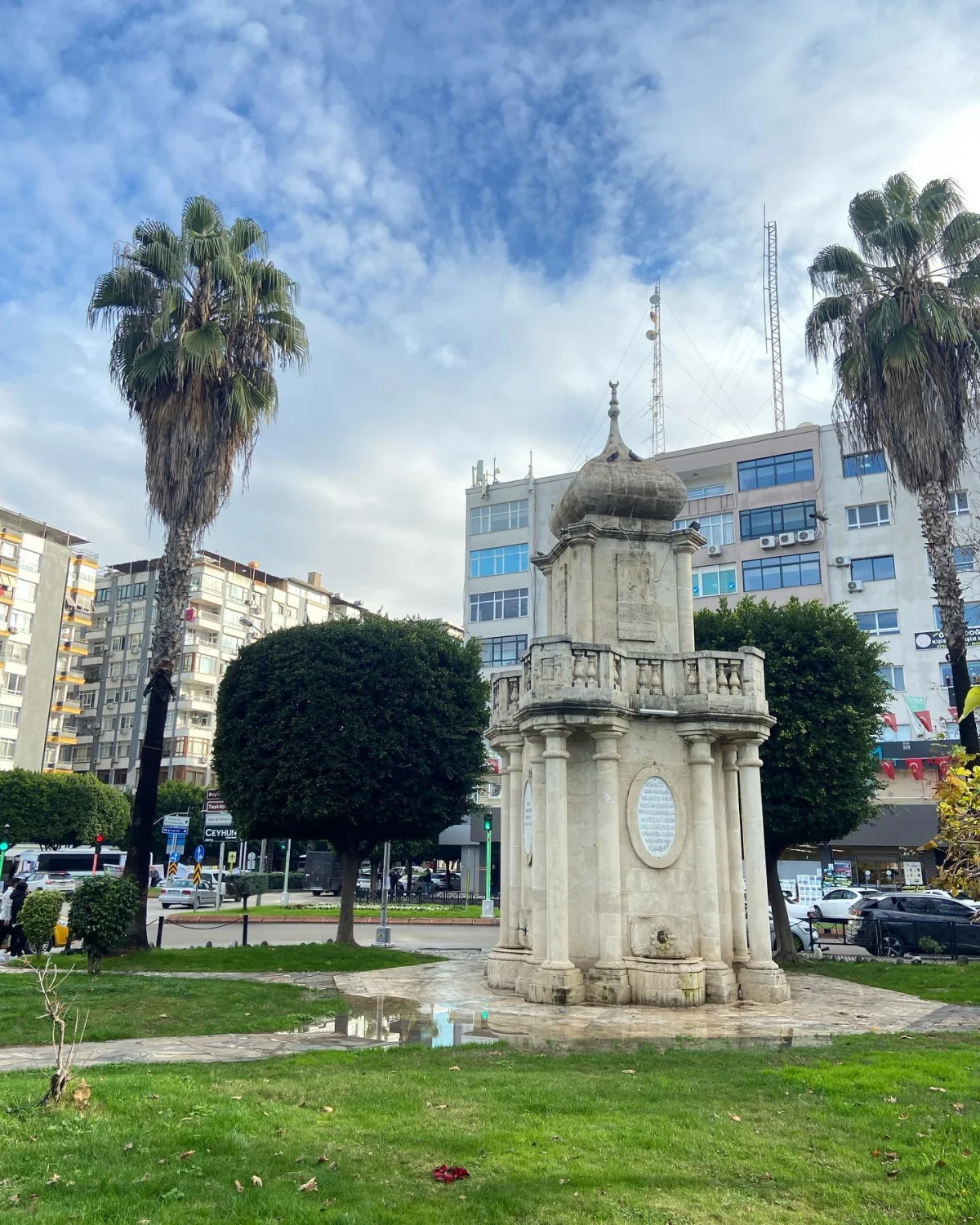 Tarihi Bahri Paşa Çeşmesi, palmiyelerle çevrili yeşil alanda yer alıyor.