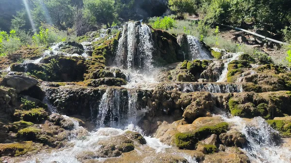 Küp şelaleleri, yeşil bitkilerle çevrili doğal bir manzara.