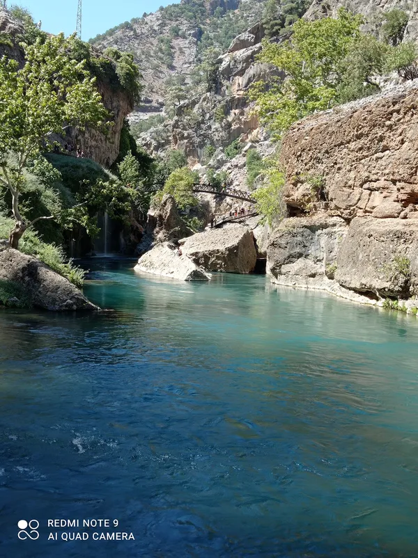 Küp şelaleleri ve doğal kanyon manzarası, yürüyen insanlar.