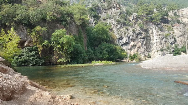 Küp şelaleleri manzarası, yemyeşil orman ve berrak su.