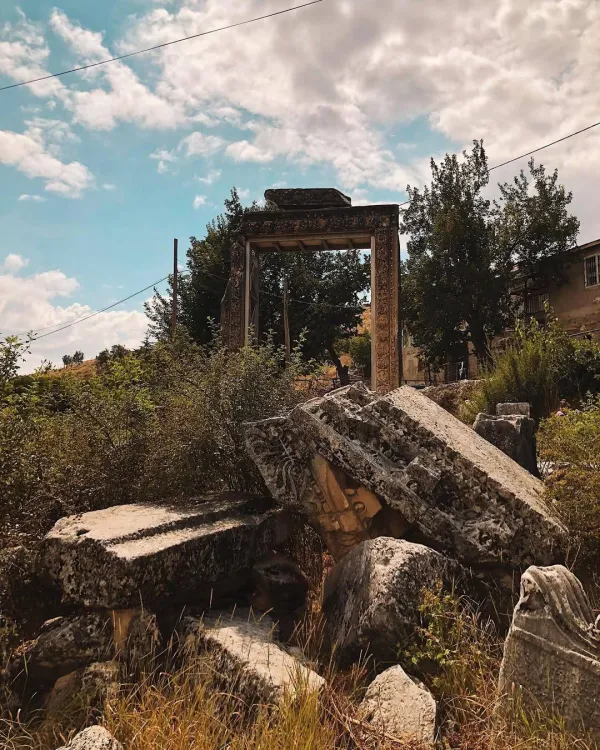 Tarihi kalıntı, süslemeli giriş yapısı ve doğal bitki örtüsü ile huzurlu bir manzara