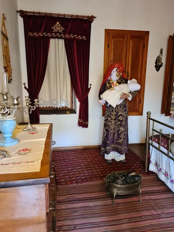 Geleneksel Adana evi iç mekânı, kadın figürü ve tarihi detaylar.