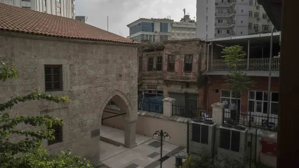 Kuruköprü Anıt Müzesi avlusunda tarihi taş yapı ve modern bina kontrastı