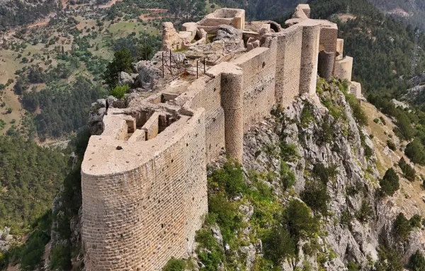 Yüksek bir dağın zirvesindeki Feke Kalesi'nin etkileyici kalıntıları ve doğal çevresi