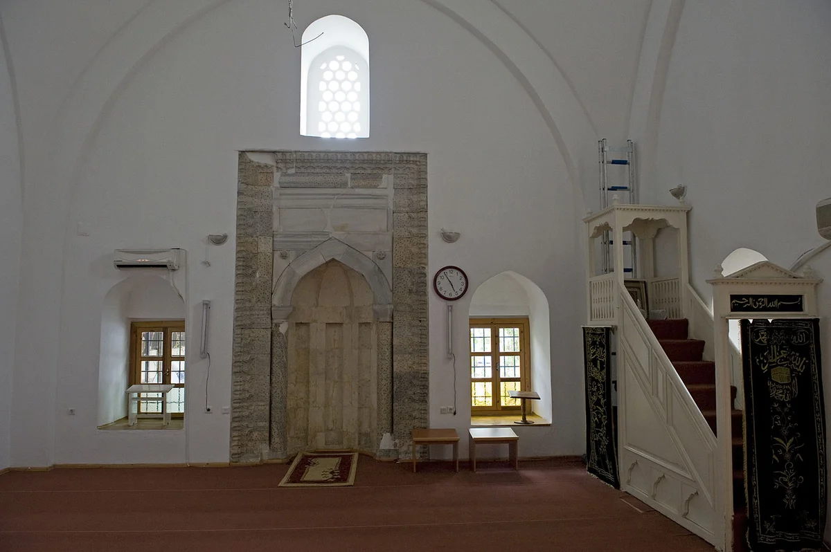 Hasan Ağa Camii'nin içindeki huzur dolu atmosfer - ahşap detaylar ve yüksek tavan! Açık renk duvarlar, ahşap detaylar ve yüksek tavan ile Hasan Ağa Camii iç mekan görüntüsü.