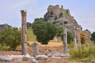 Kastabala'nın Tarihi Kalıntıları - Sütunlar ve Kale Kastabala Antik Kenti'nde sütunlar ve kale, yaz gününde tarihi keşif atmosferi.