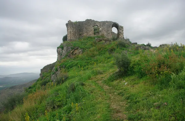 Yeşil tepe üzerindeki eski Kozan Kalesi, taş yapısı ve pencereleriyle dikkat çekiyor.