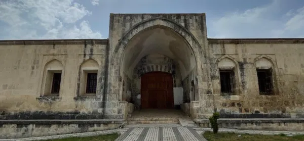 Tarihi taş yapının geniş kemerli kapısı ve yuvarlak pencereleri