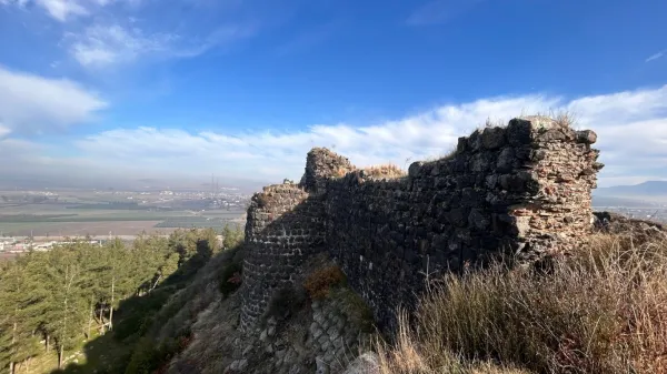 Doğal bitki örtüsüyle kaplı taş duvarlar ve vadi manzarası