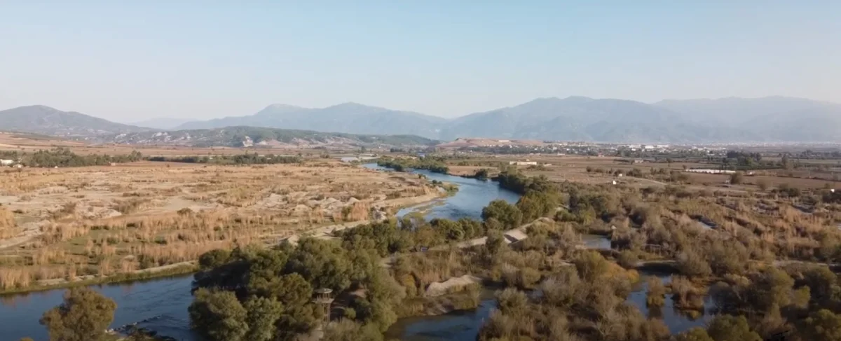 Doğal Güzellikler - Kıvrılan Nehir ve Dağ Manzarası Geniş doğal manzarada kıvrılan nehir, ağaçlık alanlar ve dağlar görünmekte.