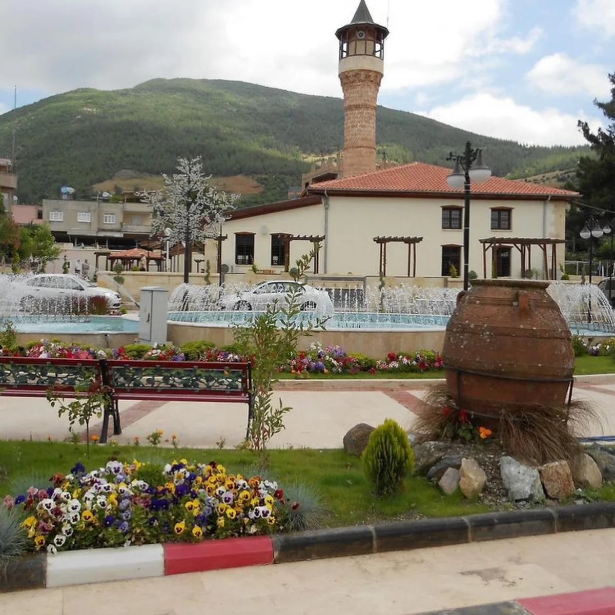 Ağcabey Camii’nin Sırları - Tarih ve Doğa Buluşuyor mu? Ağcabey Camii'nin çevresindeki doğal manzara, su çeşmesi ve çiçeklerle dolu meydan.