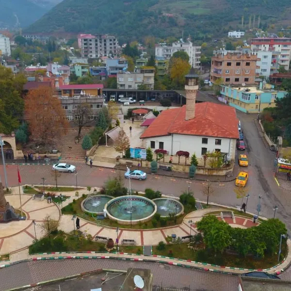Ağcabey Camii'nin önünde yer alan park ve çeşme ile şehir manzarası.
