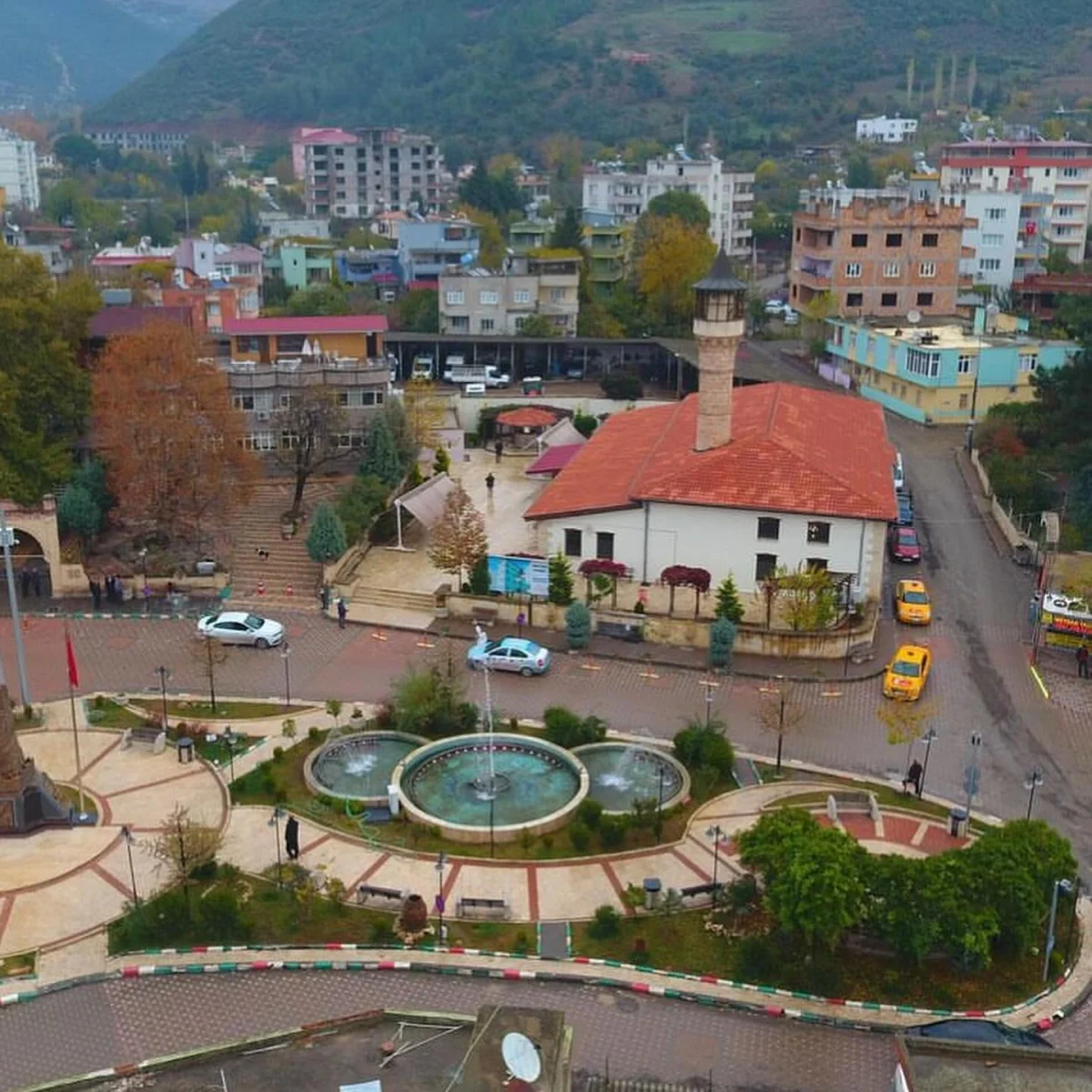 Osmaniye'de Ağcabey Camii'nden Şehir Manzarasına Yolculuk! - Tarih ve Doğanın Buluşma Noktası? Ağcabey Camii'nin önünde yer alan park ve çeşme ile şehir manzarası.