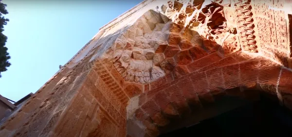 Yüksek taş duvarların detayları, geleneksel motifler ve sıcak tonlar ile tarihi yapı.