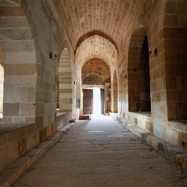 Taş yapılarla çevrili yüksek kemerli tavanlı geniş koridor