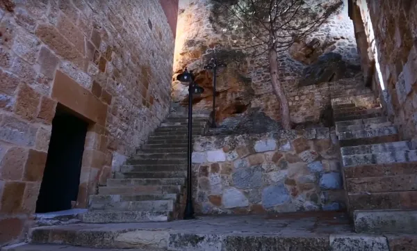 Taş döşeli merdiven, yanlarında taş duvarlar ve ağaçlarla huzurlu bir atmosfer yaratıyor.