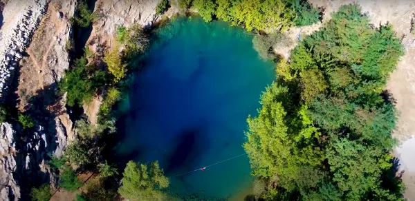 Derin, berrak bir gölet ve etrafındaki yoğun yeşil bitki örtüsü