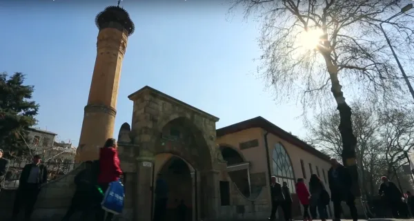 Tarihi Kahramanmaraş Ulu Cami önünde insanlar ve yüksek minare.