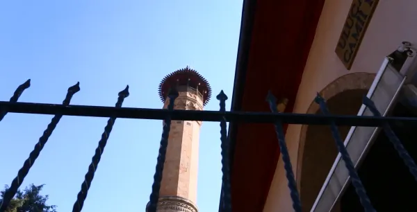 Kahramanmaraş Ulu Cami'nin uzun minaresi, açık mavi gökyüzü ile ön planda.