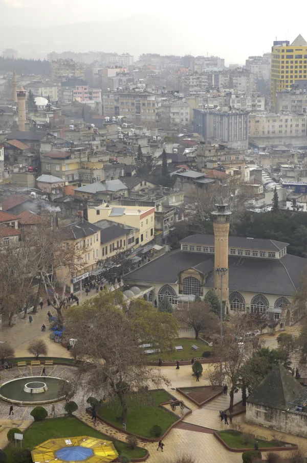 Kahramanmaraş Ulu Camii'nin minaresi ve şehir manzarası, bulutlu havada görüntülenmiş.