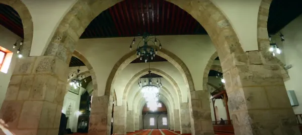 Kahramanmaraş Ulu Cami'nin geniş iç mekanı, taş sütunlar ve asma ışıklarla süslenmiş tavanı ile dikkat çekiyor.