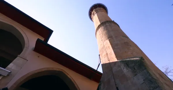 Kahramanmaraş Ulu Cami'nin yüksek taş minaresi, yuvarlak şapka ve sivri uçlarla çevrili.