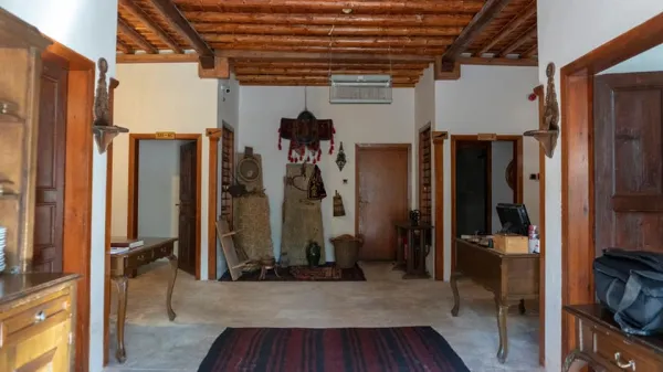 Geleneksel otel lobisi, ahşap kirişler ve Türk halılarıyla dekore edilmiş.