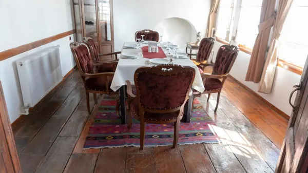 Şık bir yemek masası, zarif tabaklar ve doğal ışıkla aydınlatılmış bir oda