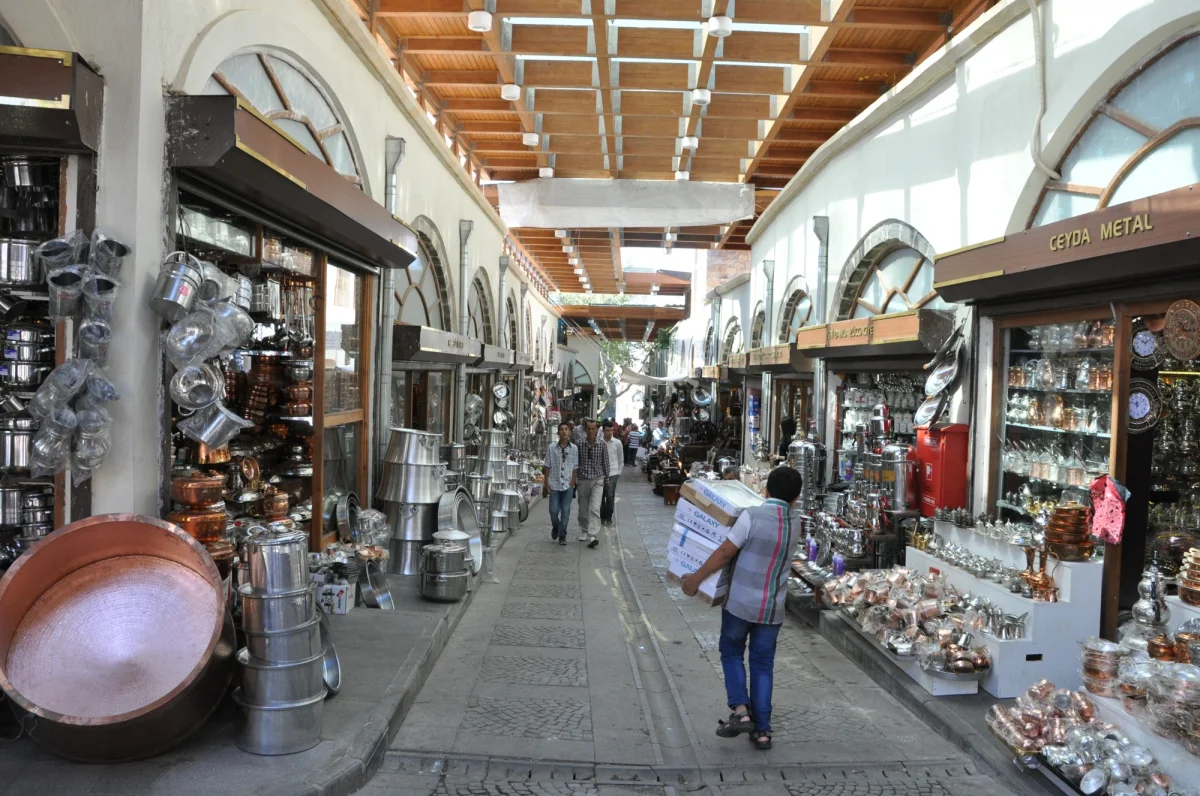 Tarihi Maraş Çarşıları - Metal Eşyaların Büyüsü! Dar sokakta sıralanan dükkanlar, bakır ve gümüş eşyalarla dolu.