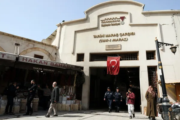 Tarihi Maraş Çarşısı girişinde Türk bayrağı dalgalanıyor, insanlar alışveriş yapıyor.